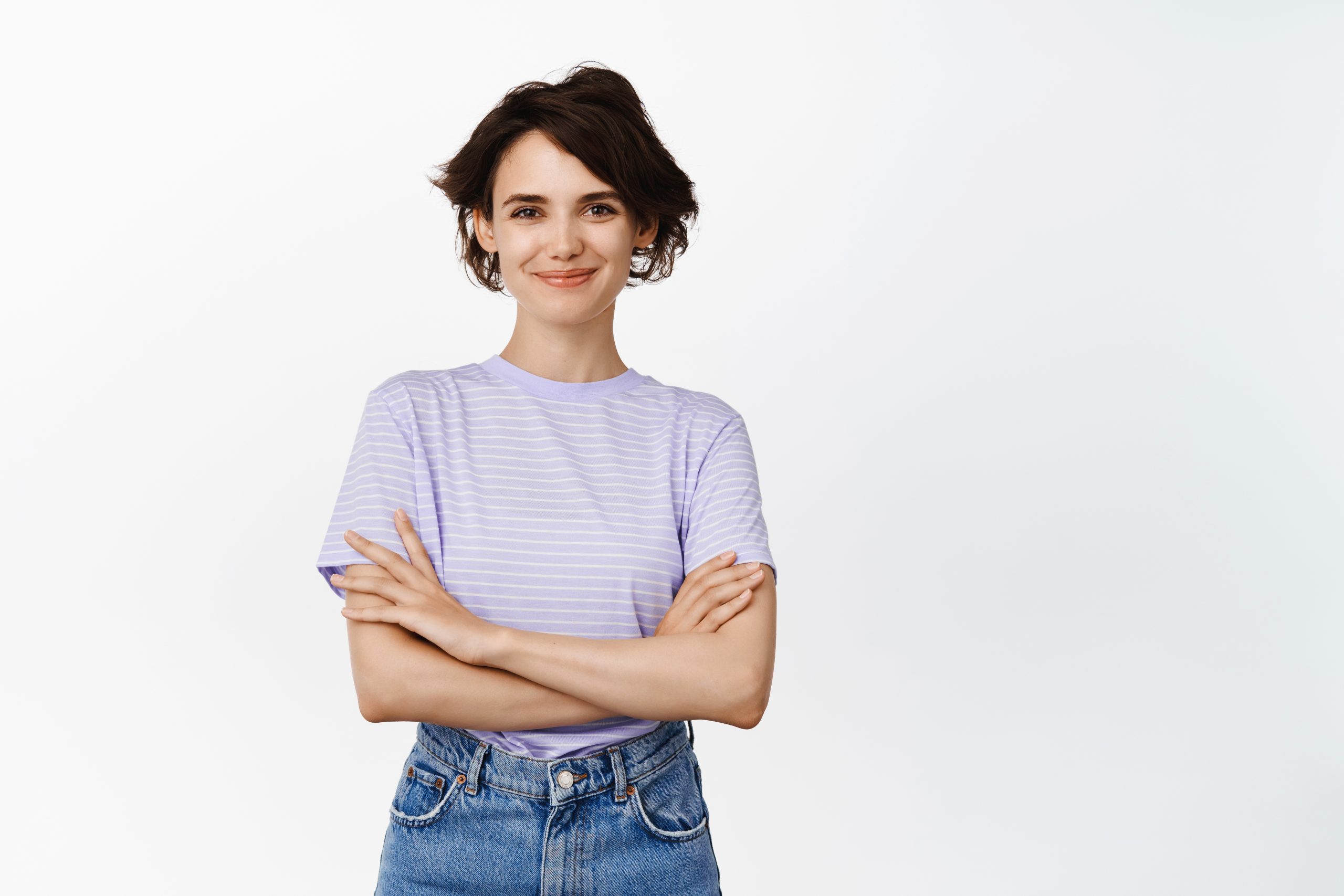 Image of confident brunette female model, girl looks assertive and ready, cross arms on chest like professional, smiling smug face, standing over white background