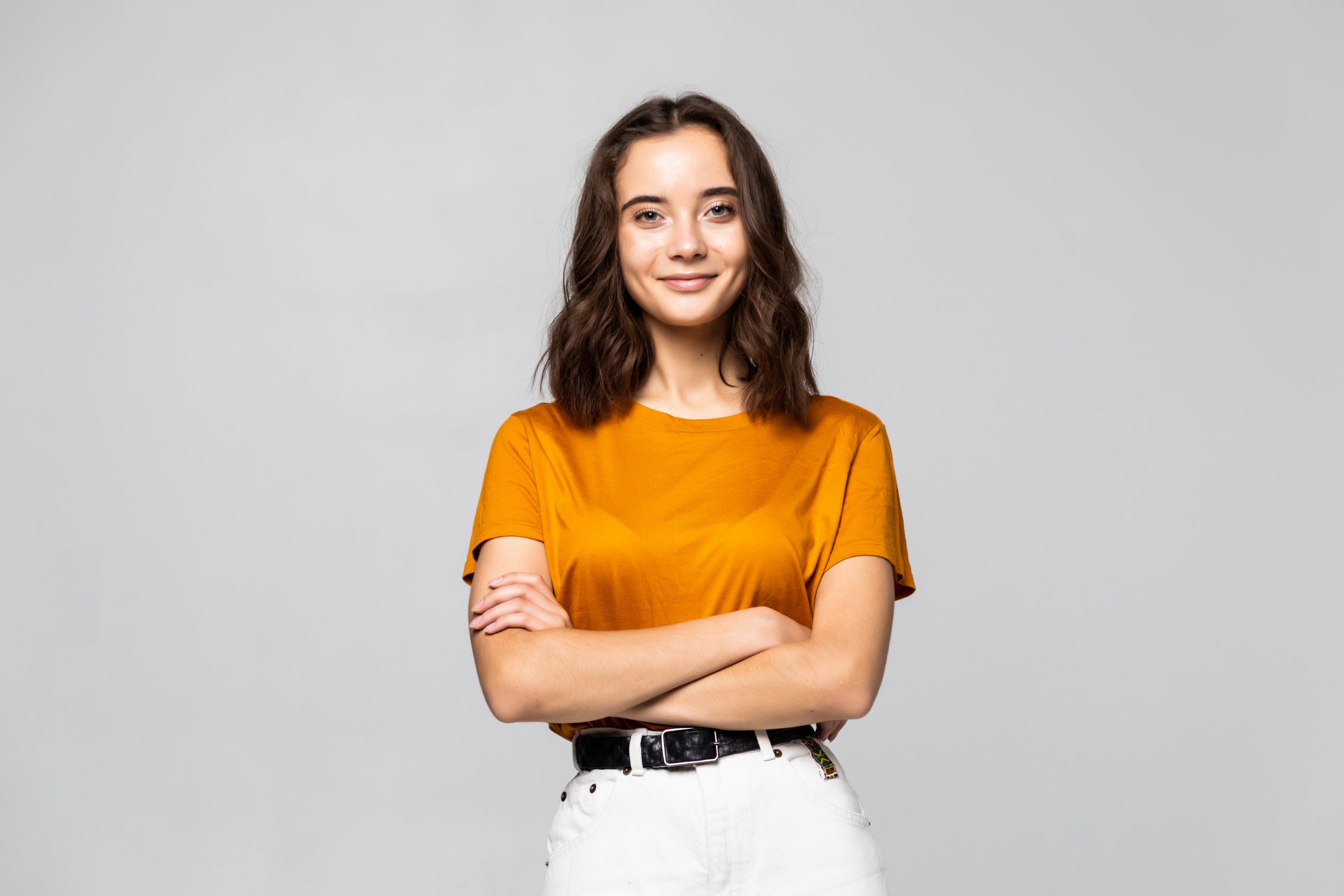 Portrait of beautiful young woman standing on grey background
